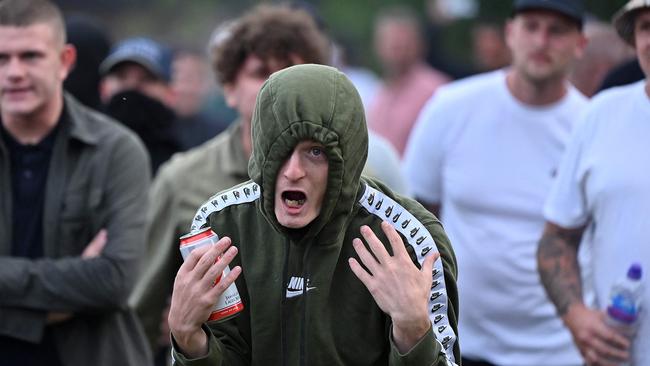 A protester gestures at riot police as clashes erupt in Bristol on August 3. Picture: AFP