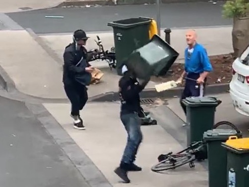 One of the attackers throws a wheelie bin at the elderly man as they start to get the upper hand. Picture: Supplied