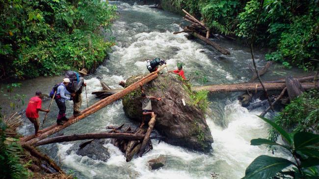 Easy does it … trekkers tackle a river crossing on the 96km Kokoda Track.