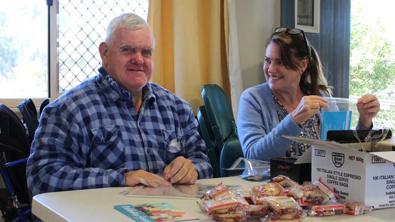 Carinity Our House Lifestyle Support Worker Louise Northey assists Hugo Teske to make Queensland Seniors Week gift packs. Photo: Supplied.