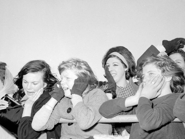 1964. The Beatles in Melbourne. Tearful teenagers press against a fence to get a last glimpse of the Beatles as they board thier plane for Sydney. Fans. Crowd. Picture: News Corp