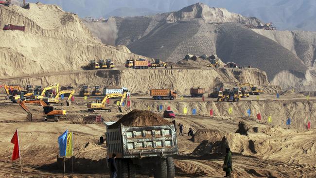 In this photo taken Monday Dec. 10, 2012, earth moving vehicles are seen at work at a site in Baidaoping area in Lanzhou in northwest China's Gansu province. China's campaign to shave off mountaintops and fill in valleys to make way for cities may come at too high a price in the pollution, erosion and flooding unleashed by the unprecedented redistribution of earth, Chinese researchers warned Thursday June 5, 2014. (AP Photo) CHINA OUT