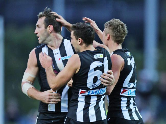 Collingwood teammates rush to Cloke after one of his goals. Picture: Nathan Dyer
