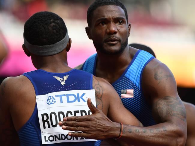 US athlete Justin Gatlin (R) embraces US athlete Mike Rogers (L) after the USA won their heat of the men's 4x100m relay athletics event at the 2017 IAAF World Championships at the London Stadium in London on August 12, 2017. / AFP PHOTO / Jewel SAMAD