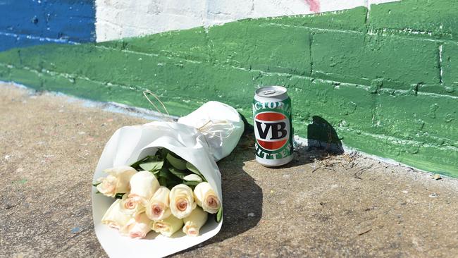 Flowers and a VB can at the mural in Black Rock. Picture: Josie Hayden