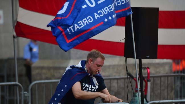 A Trump supporter smokes a cigarette while affixing audio cables to a police barricade in Pennsylvania, Philadelphia, six days after the general election on November 9. Picture: Getty Images/AFP