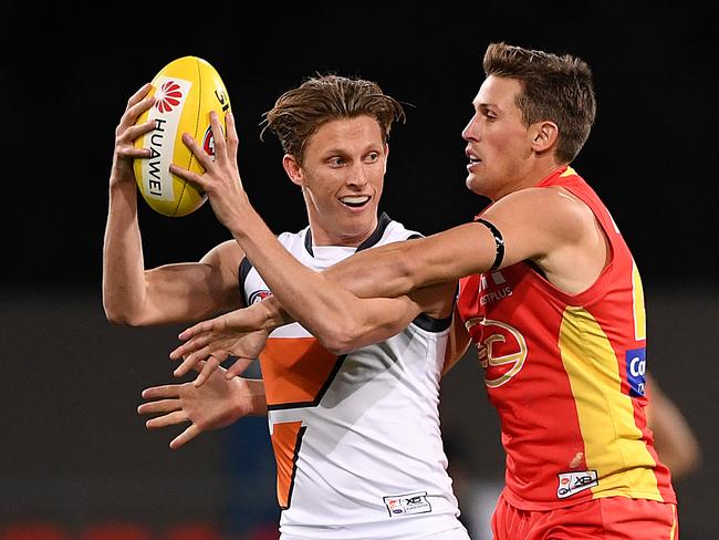 Lachie Whitfield of the Giants (left) marks in front of David Swallow of the Suns during the Round 23 AFL match between the Gold Coast Suns and the GWS Giants at Metricon Stadium on the Gold Coast, Saturday, August 24, 2019. (AAP Image/Dave Hunt)