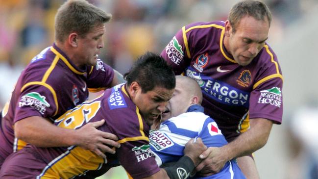 Shane Webcke, Carl Webb and Gorden Tallis tackle Mark O’Meley in 2004.