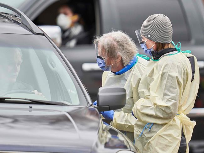 (FILES) In this file photo taken on March 17, 2020 health care workers speak with patients at a drive-thru Covid-19 assessment center in London, Ontario. - Canada surpassed 500,000 coronavirus cases on December 19, 2020, according to official figures, recording a 25 percent increase in just two weeks. The country's death toll since the beginning of the pandemic stands at 14,128, according to regional figures quoted by broadcaster CBC. (Photo by Geoff Robins / AFP)