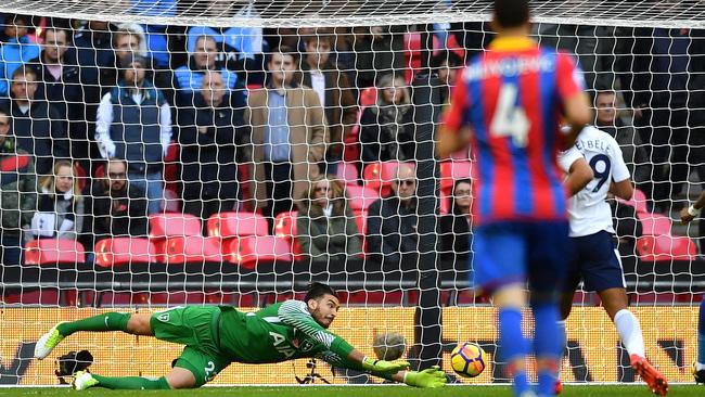 Tottenham Hotspur's Argentinian goalkeeper Paulo Gazzaniga (L) dives to save a shot from Crystal Palace's English midfielder Andros Townsend (unseen).