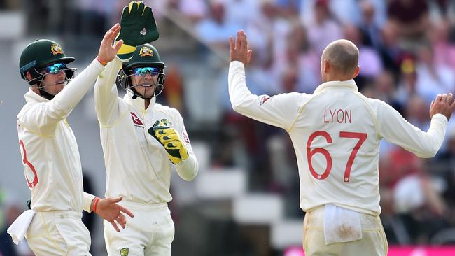 Nathan Lyon, right, and Tim Paine, centre, celebrate the wicket of England's Stuart Broad for 11 runs. Picture: AFP