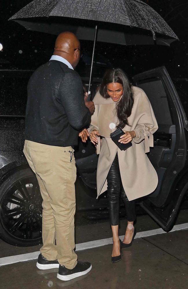 The Duchess of Sussex is sheltered from the rain outside the Hollywood hotspot. Picture: The Daily Stardust / ShotbyNYP/MEGA / BACKGRID