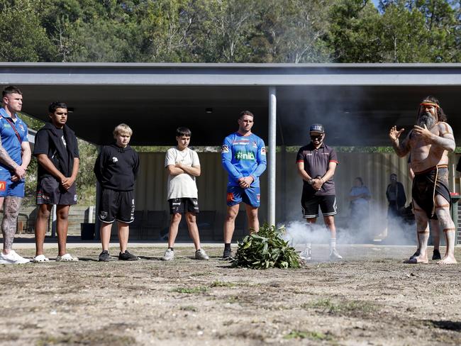 Justin Ridgeway leads the smoking ceremony with local kids and Newcastle Knights players. Picture: Michael Gorton