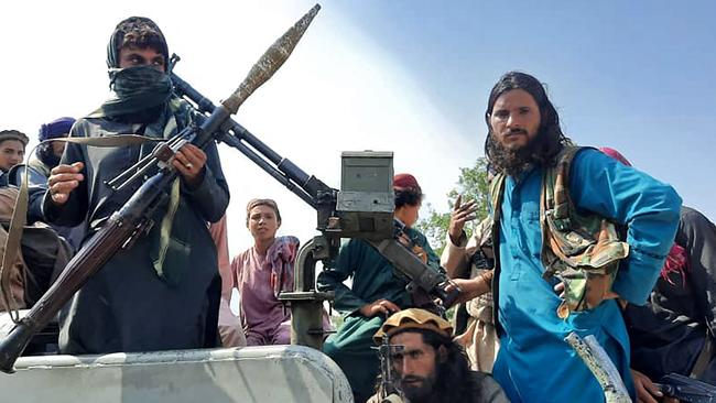 Taliban fighters sit over a vehicle on a street in Laghman province on August 15. Picture: AFP