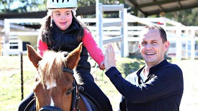 Champion trainer Chris Waller shares a high five with eight-year-old after making a donation to the Pony Riding for the Disabled Association in Brisbane. Picture: Annette Dew