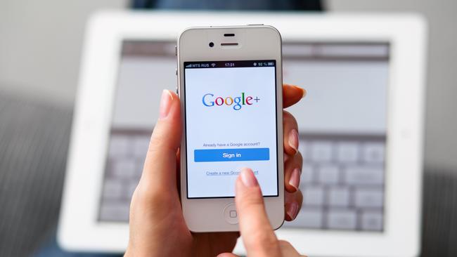 Nizhnevartovsk, Russia - March 11, 2013: Woman hand holding iPhone with Google Plus App and using tPad. Google Inc. is an American multinational corporation that provides Internet-related products and services, including internet search, cloud computing, software and advertising technologies.