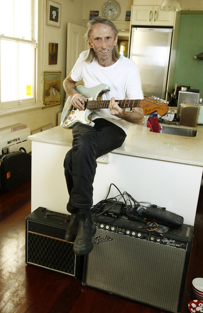 Reg Mombassa playing his 1969 Blue L series Fender Startocaster guitar in the kitchen. At Home with musician and artist Reg Mombassa. Picture: John Appleyard