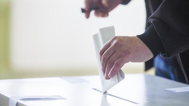 Hand of a person casting a ballot at a polling station during voting. election voting vote polling poll generic Townsville