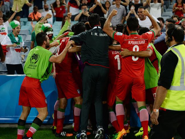 Iran celebrates scoring the opening goal with their fans against Qatar in their Group C football match in the AFC Asian Cup in Sydney on January 15, 2015. AFP PHOTO/Peter PARKS --IMAGE RESTRICTED TO EDITORIAL USE - STRICTLY NO COMMERCIAL USE