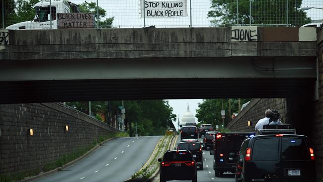 Signs hang above the road as US President Donald Trump and First Lady Melania Trump's motorcade passes on their way to visit the Saint John Paul II National Shrine in Washington, DC.