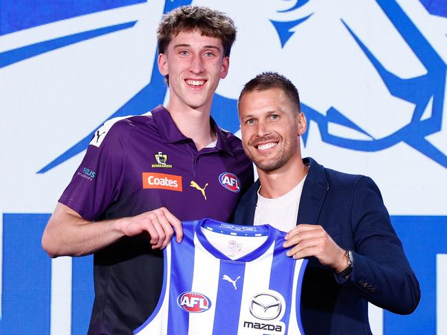 MELBOURNE, AUSTRALIA - NOVEMBER 20: The number 27 pick, Matt Whitlock is presented his North Melbourne Kangaroos jumper by Andrew Swallow during the 2024 Telstra AFL Draft at Marvel Stadium on November 20, 2024 in Melbourne, Australia. (Photo by Michael Willson/AFL Photos via Getty Images)