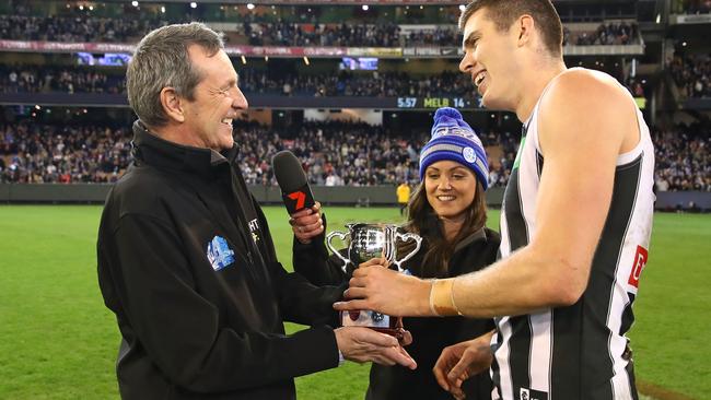 Mason Cox of the Magpies is presented with the man of the match award by Neale Daniher after his fine effort in the Queen’s Birthday clash at the MCG. Picture: Scott Barbour/AFL Media/Getty Images