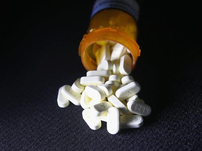 (FILES) In this file photo Oxycodone pain pills prescribed for a patient with chronic pain lie on display on March 23, 2016 in Norwich, Connecticut. - US drug companies face hundreds of millions of dollars in damages for fomenting opioid addiction as a trial opened on May 3, 2021 in West Virginia, one of the states most devastated by the epidemic. Leading pharmaceutical makers and distributors, including bankrupt Oxycontin pioneers Purdue Pharma, drugs distribution giant AmerisourceBergen, and top pharmacy chain CVS, are accused by the city of Huntington and its surrounding county of pumping highly addictive painkillers into the state, stoking a widespread addiction and overdose crisis that continues today. (Photo by JOHN MOORE / GETTY IMAGES NORTH AMERICA / AFP)