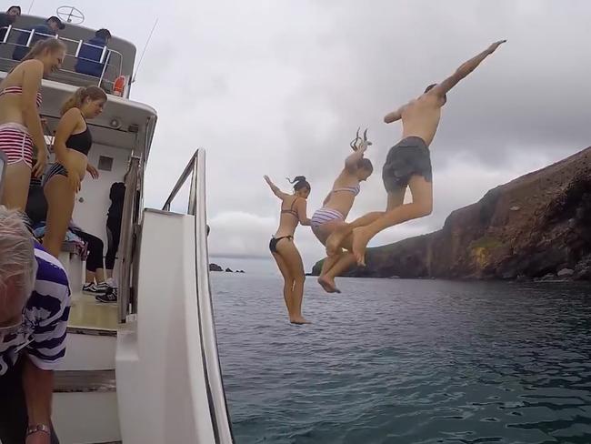 Former tourists of White Island jumping off the boat into the water for a swim. Picture: Still from White Island Active Volcano Tour in Whakatane – New Zealand's Biggest Gap Year – Backpacker Guide, 2018, from NZ Pocket Guide YouTube Channel