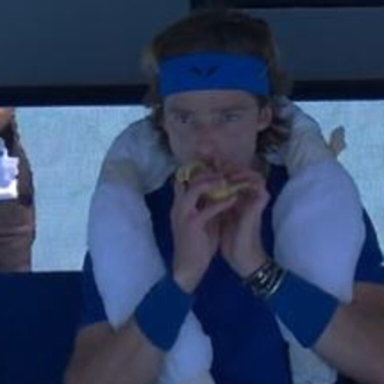 Andrey Rublev eating a banana donated by Daniel Evans.