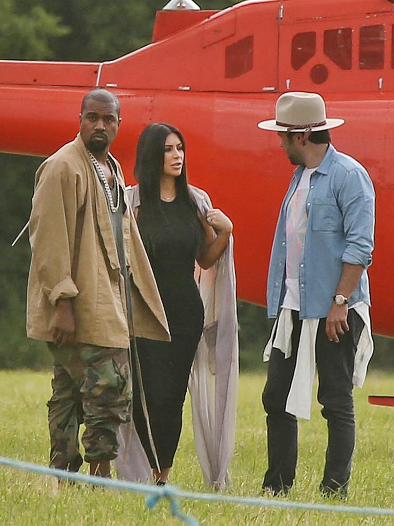 Kanye West and Kim Kardashian speak to an unidentified friend as they arrive by helicopter at the 2015 Glastonbury Festival. Picture: AAP