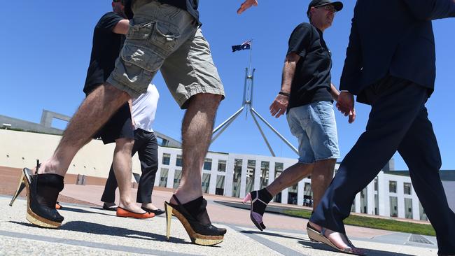 Male Bureaucrats of the Department of Foreign Affairs and Trade take part in the ‘Walk a mile in her shoes’ campaign outside Parliament House. Picture: AAP Image/Lukas Coch)