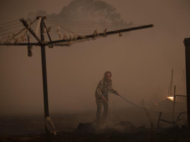 Clair Cowie defends her home from a spot fire. Picture: Brook Mitchell/Getty Images