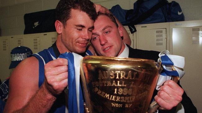 John Longmire, pictured with champion teammate Wayne Carey, missed the Kangaroos’ 1996 flag with a serious knee injury.