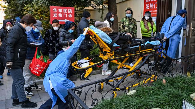 Staff in protective clothes transport a patient to a fever clinic in Shanghai on Monday. Picture: AFP