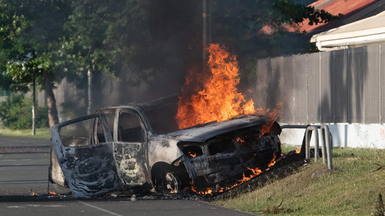 A car is burning on the Normandie provincial road, outside Noumea on May 16, 2024, amid protests linked to a debate on a constitutional bill aimed at enlarging the electorate for upcoming elections of the overseas French territory of New Caledonia. France deployed troops to New Caledonia's ports and international airport, banned TikTok and imposed a state of emergency on May 16 after three nights of clashes that have left four dead and hundreds wounded. Pro-independence, largely indigenous protests against a French plan to impose new voting rules on its Pacific archipelago have spiralled into the deadliest violence since the 1980s, with a police officer among several killed by gunfire. (Photo by Delphine Mayeur / AFP)