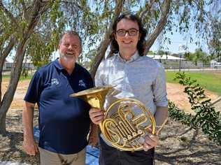 Music teacher Sam Muller (right) holds the French Horn, gifted to his student by Wayne Thompson of Rural Aid. Picture: Contributed