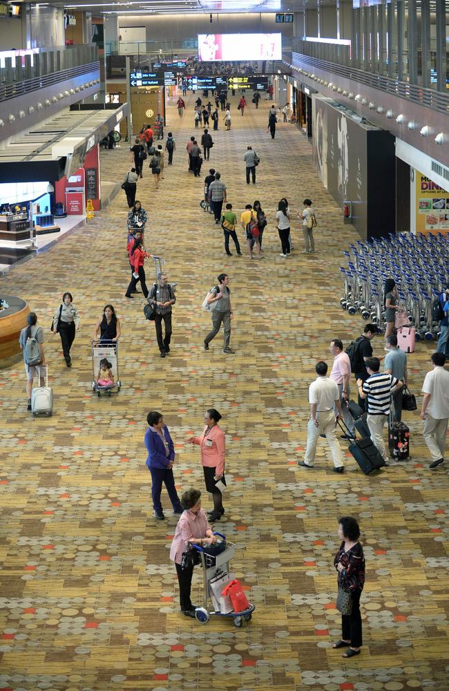 Passengers in the transit hall of Changi International Airport.