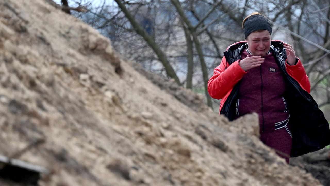 A relative reacts after the body of a civilian was exhumed from a shallow grave near the village of Andriivka, Kyiv region. Picture: Sergei SUPINSKY / AFP