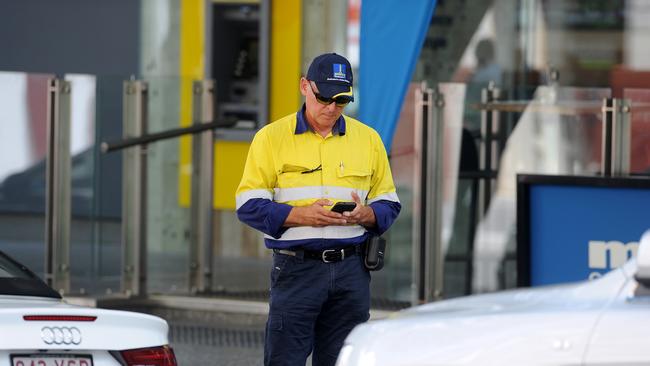 Brisbane City Council parking ranger checks parked car in the Brisbane CBD. (AAP image, John Gass)