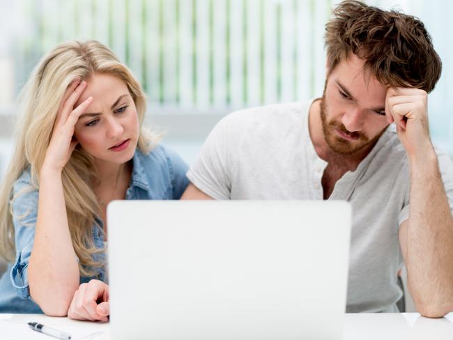 A young couple discussing their finances with each other in front of their computer at home. Picture: iStock.