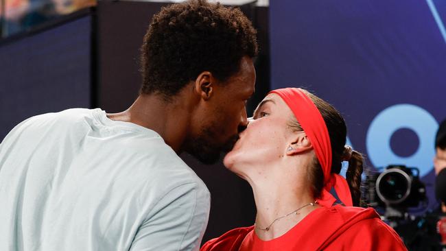 Gael Monfils (left) kisses his wife Elina Svitolina after she caused a stunning upset against world No. 4 Jasmine Paolini in the third round. Picture: Martin Keep / AFP