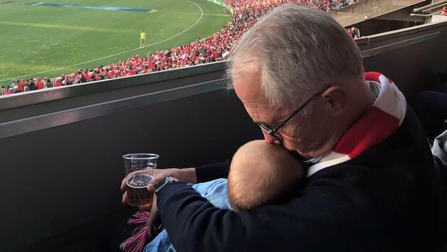 This pic of Prime Minister Malcolm Turnbull holding his baby granddaughter Alice during the Swans v Bombers match in Sydney on the weekend has copped a lot of criticism.  Picture: AFP/Office of the Prime Minister