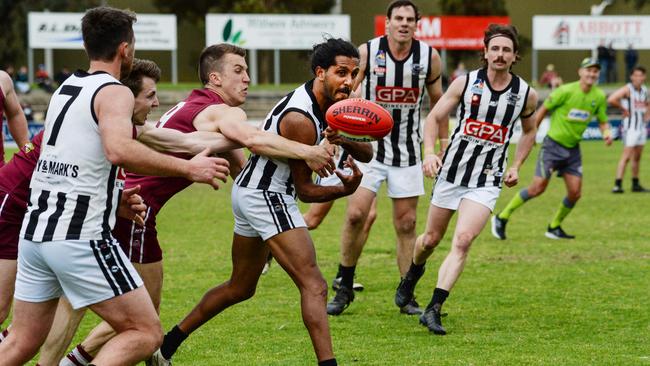 PNU’s Anthony Wilson handballs under pressure from Jack Trengove during the Adelaide Footy League division one grand final against Prince Alfred Old Collegians. It was a day to forget for the club. Picture: Brenton Edwards