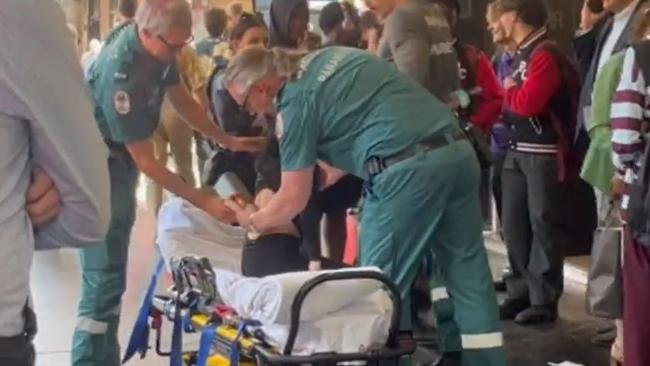 Paramedics with the woman after she was stabbed. Picture: 9 News