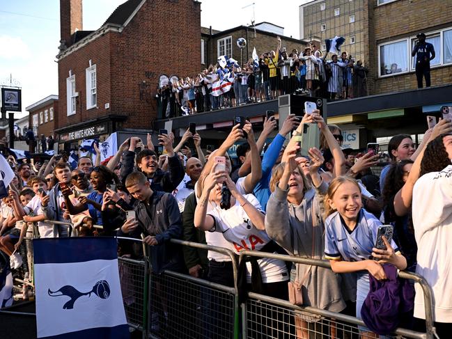 Fans of Tottenham Hotspur hold up phones as the bus passes. Picture: Getty Images