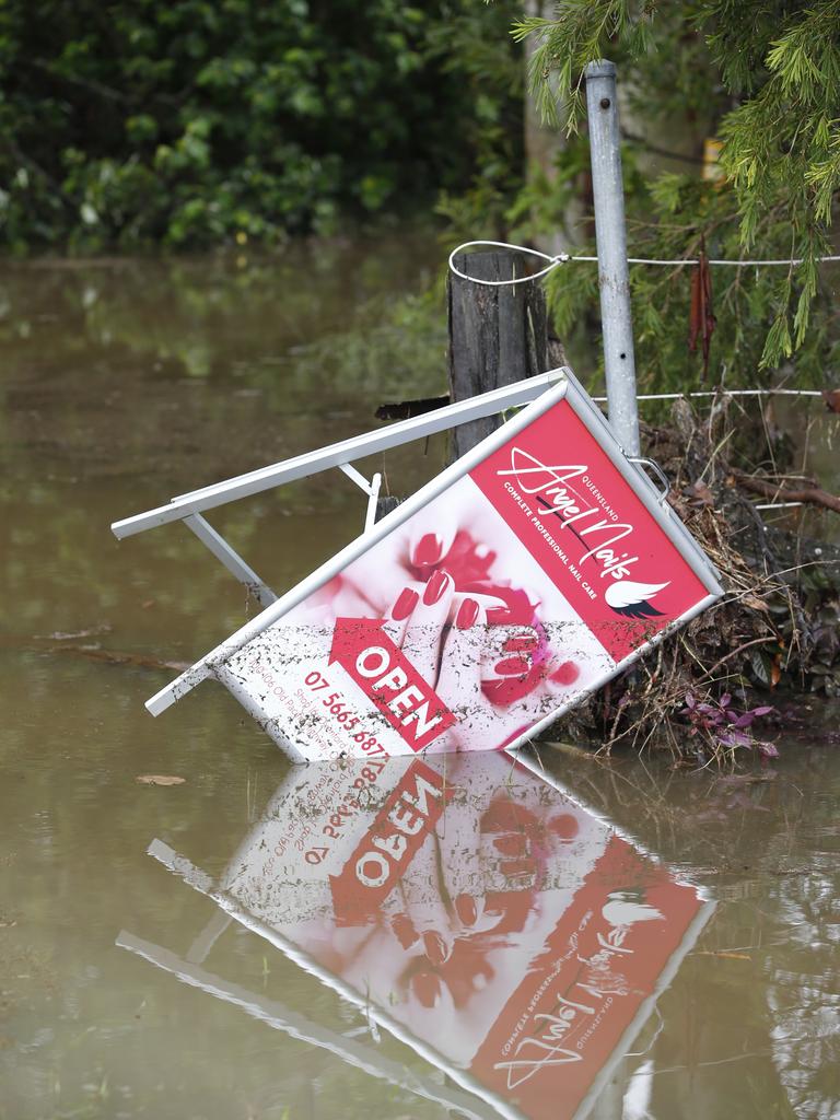 A business signage is seen swept by the flash flood near Oxenford Plaza, Oxenford, Gold Coast, Saturday, January 18, 2020. A severe thunder storm swept the Coast during the early hours of the day dumping 128mm of rain in an hour. (AAP Image/Regi Varghese)