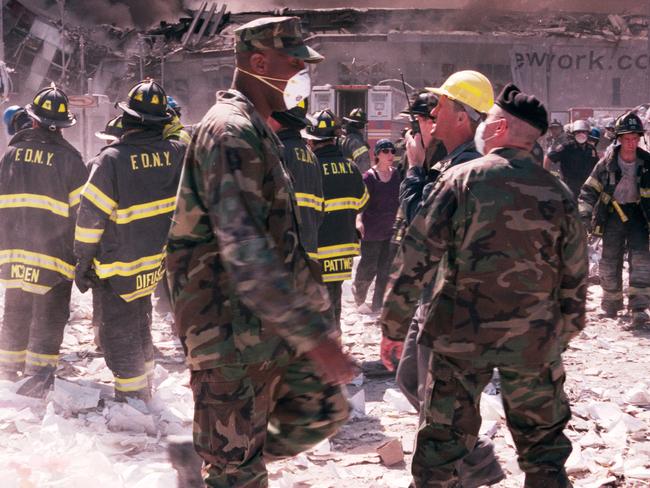 New York City firefighters and military personnel stand near the area known as Ground Zero after the collapse of the Twin Towers. Picture: Anthony Correia