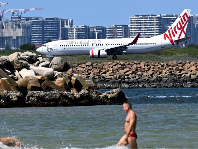 A Virgin Australia plane taxis upon arriving at Sydney International Airport on February 27, 2025. Australia will let Qatar Airways buy a 25 percent stake in troubled airline Virgin Australia, a senior government minister said, injecting foreign competition into the nation's Qantas-dominated aviation sector. (Photo by Saeed KHAN / AFP)
