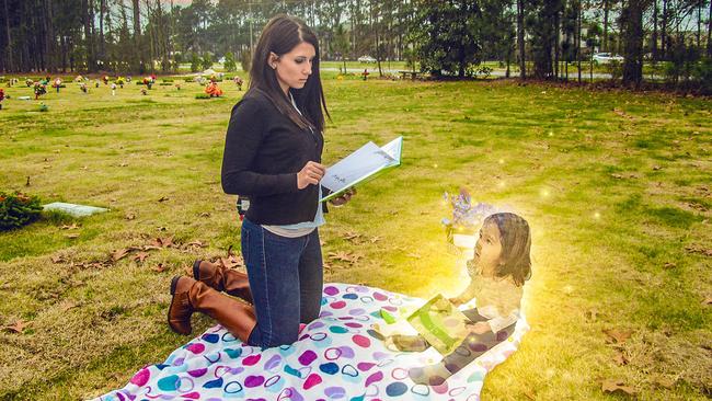 Jeanie Ditty reading Macy Grace’s favourite book to her at her gravestone.