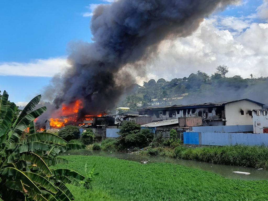 Flames rise from buildings in Honiara’s Chinatown on November 26, 2021. Picture: Charley Piringi/AFP